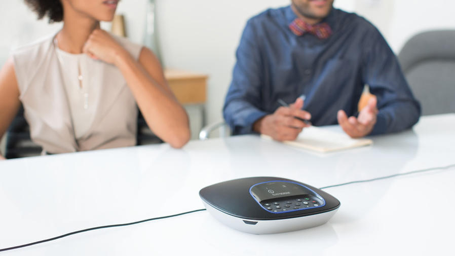 People at conference table video conferencing