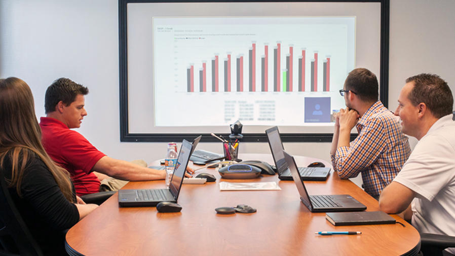 People at conference table video conferencing