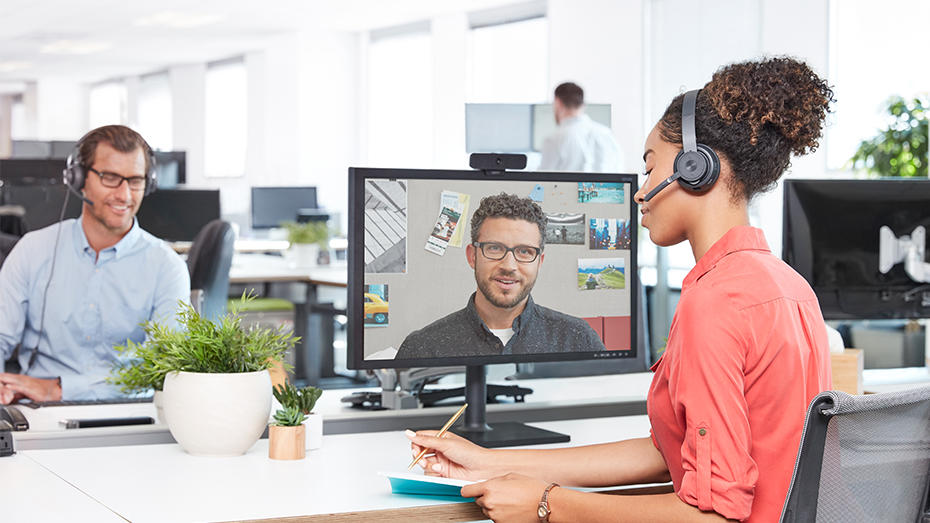 Femme travaillant au bureau et participant à une visioconférence avec un casque sans fil