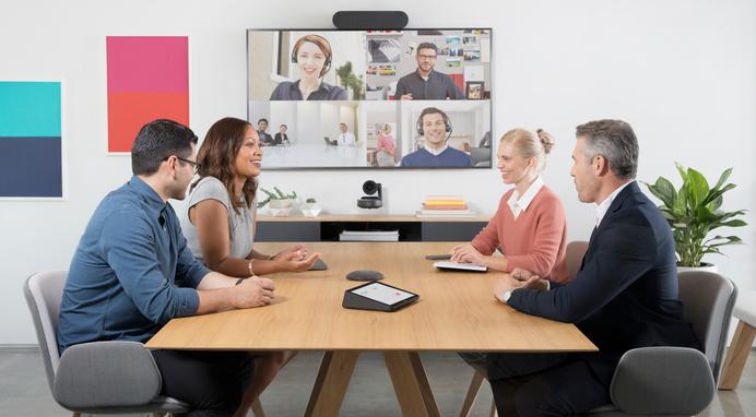 People at conference table video conferencing